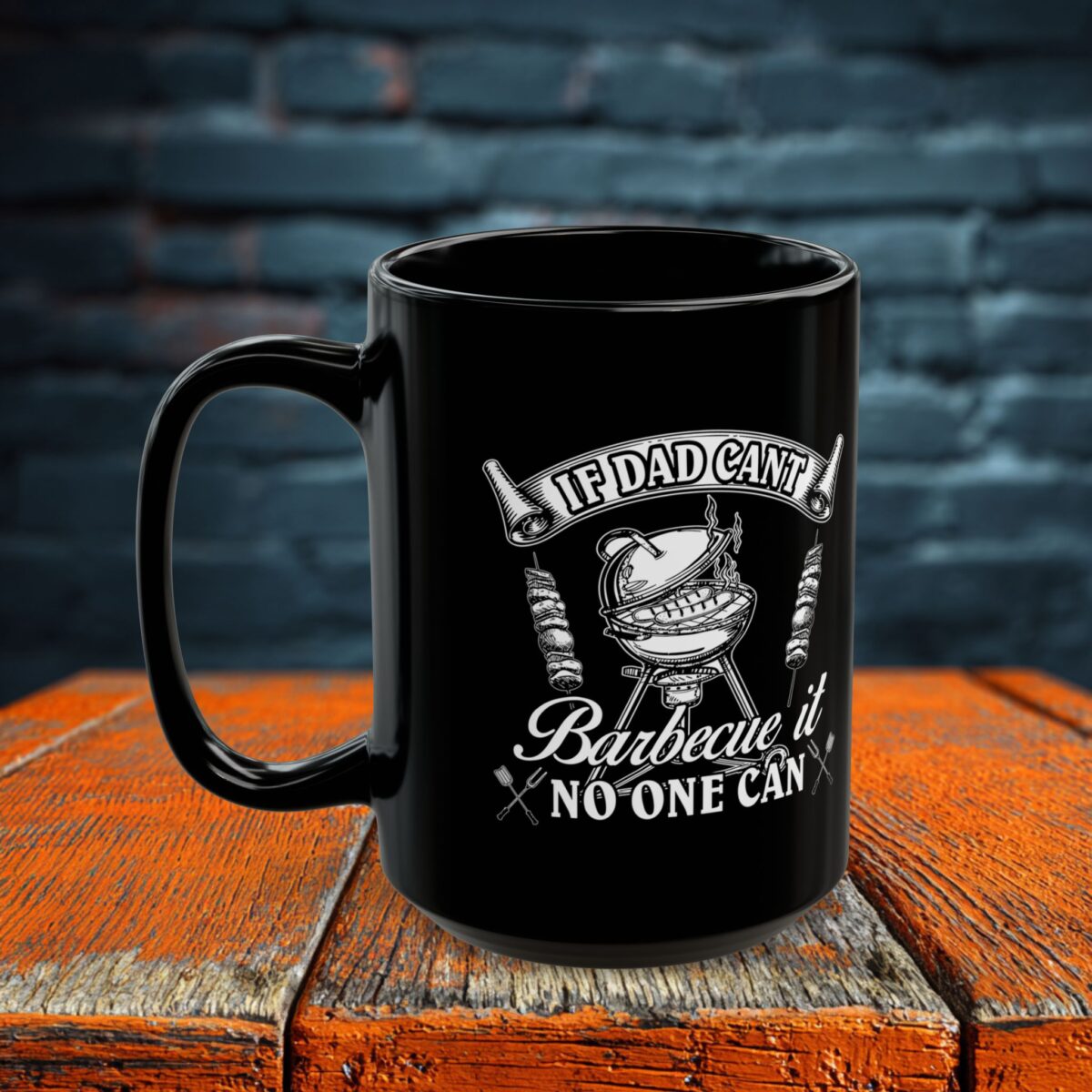 A black ceramic mug with a white graphic of a grill and text reading "If Dad Can't Barbecue It No One Can".