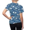 White floral branches on a blue background cover this seamless pattern tee, showcasing blooming peonies and delicate leaves.