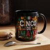Colorful Cinco De Mayo graphics, including Mexican flag, sombrero, maracas, and fiesta icons, adorn this black mug.