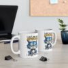 A grumpy blue cat with yellow eyes sits on a white mug, with the text 