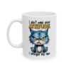 A grumpy blue cat with yellow eyes is featured on a white mug. Text above reads 'I don't need your ATTITUDE' and below reads 'I brought my own'.