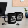 Two black ceramic mugs with white text and graphics that say "This Guy Loves Being a Builder".