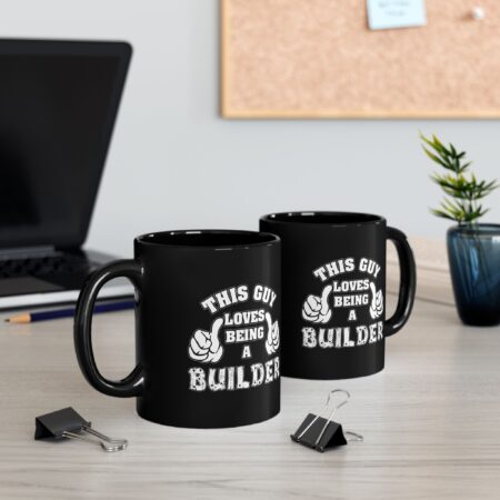 Two black ceramic mugs with white text and graphics that say "This Guy Loves Being a Builder".