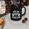 A black ceramic coffee mug with "THIS GUY LOVES BEING A BUILDER" printed in white text and graphics.