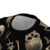 Sepia-toned skulls and bones are scattered across this all over print t-shirt on a black background.