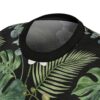 Black sublimation tee with all over print of tropical leaves, monstera, palm fronds, and white orchids.