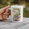 White ceramic mug with colorful floral graphics and text.