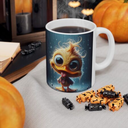 Glossy white ceramic mug features a vibrant, full-wrap print of a fluffy yellow duckling with large eyes standing in the rain against a deep blue background.