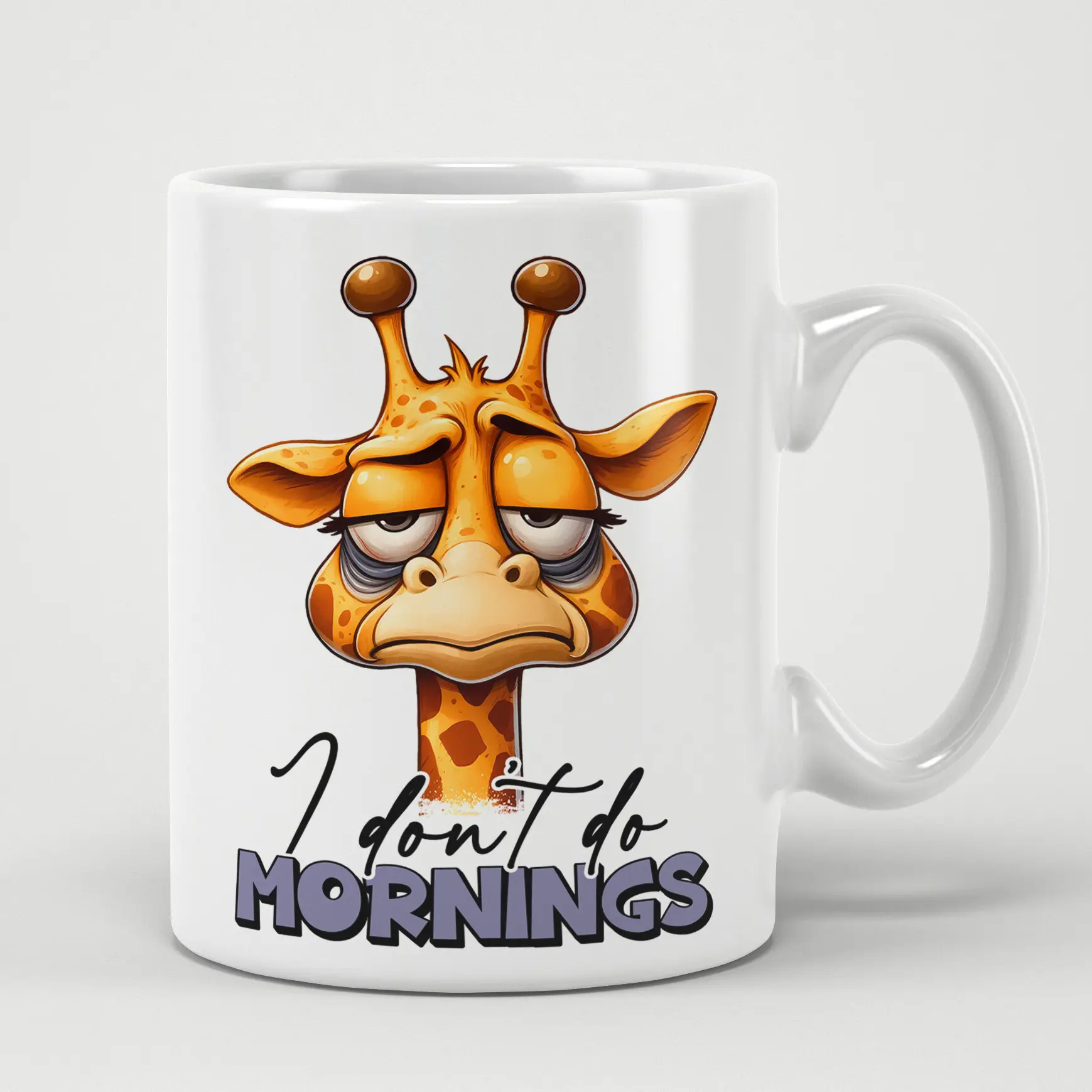 White ceramic mug with a cartoon giraffe looking tired and grumpy, with text that reads "I don't do mornings".