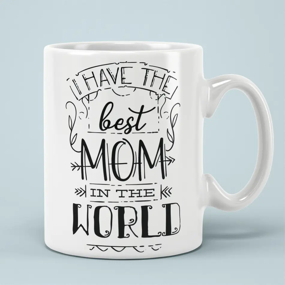 White ceramic mug with black text that reads "I HAVE THE best MOM IN THE WORLD".