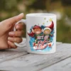 White ceramic coffee mug with a festive graphic of two elves and the text 