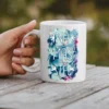 White mug with a floral design and the word 