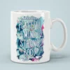 White ceramic mug with a watercolor floral design in blues, greens, and pinks. Text reads: 