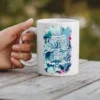 White ceramic mug with a floral design and text that says 