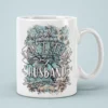 White ceramic coffee mug with a floral and tree branch design and bold text saying 