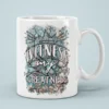 White ceramic mug with a crown and floral design, reads 