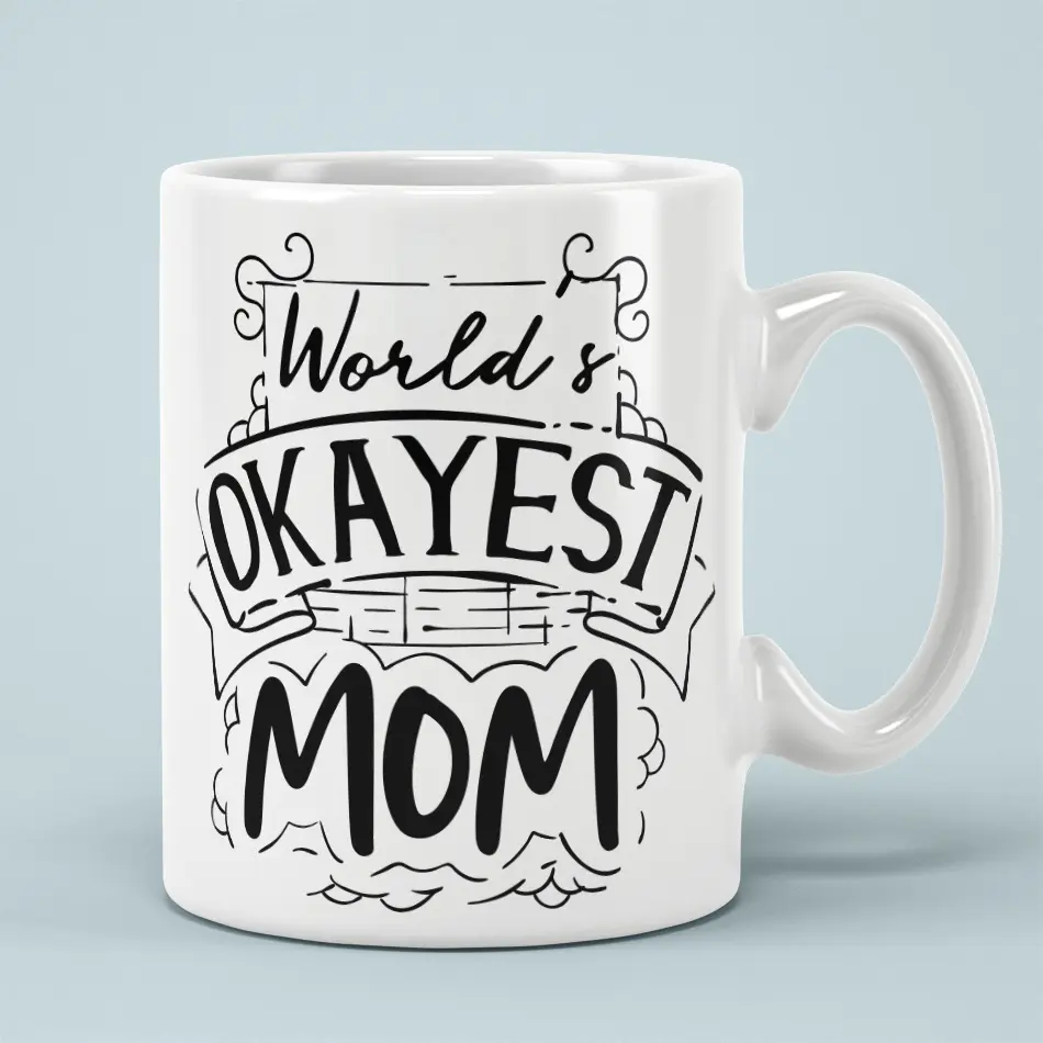 White ceramic mug with black text that reads "World's Okayest Mom" in a playful font.