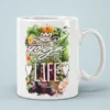 White ceramic mug with 'Yoga Life' in stylized font over a vibrant floral background.