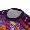 Vibrant purple sugar skulls and marigolds adorn this soft 360-degree graphic t-shirt, showcasing a detailed, colorful polyester fabric texture.