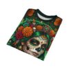 Vibrant orange marigolds and emerald green hair pop on this sublimation print tee, accented by ornate skull makeup, jewels, and feathers.