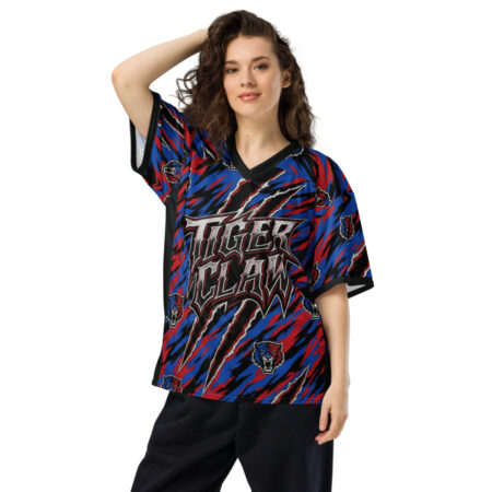 This jersey features a vibrant all over print design with red, blue, and black jagged stripes and tiger face graphics.