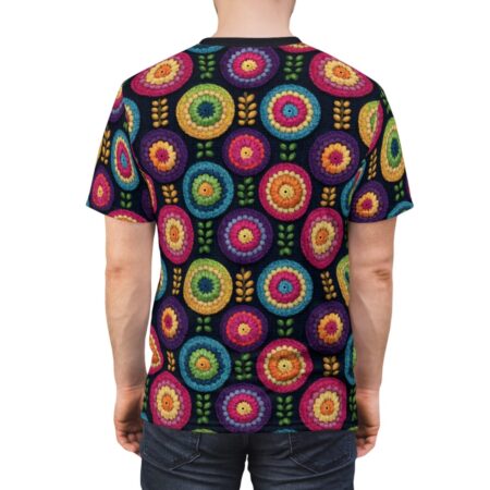 All over print t-shirt with vibrant, crochet-style circular floral patterns and green leaf accents on a dark background.