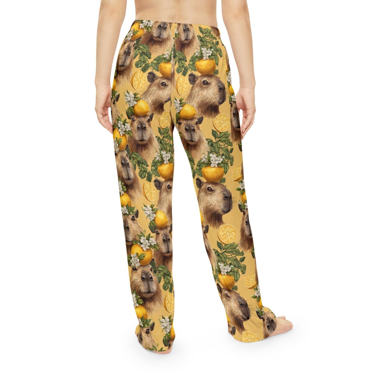 Yellow all over print pajama pants featuring a repeating pattern of capybaras with lemons and blossoms.