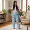 Blue lounge pants with repeating white cat faces and daisies pattern on thin blue stripes.