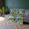 All over print fleece throw blanket with a repeating pattern of ice cream cones and yellow lemon slices on a blue background.
