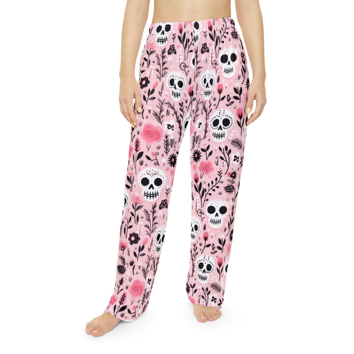 Pink all over print pajama pants featuring white sugar skull and floral designs. Seamless print wrap around graphic.