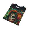 All over print sublimation tee featuring a colorful sugar skull woman with a floral crown and small skulls. Dark green background with festive flags.