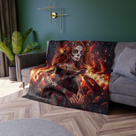 Fleece blanket with all over print of a fiery sugar skull woman with tattoos and floral accents, detailed sublimation wrap around design.