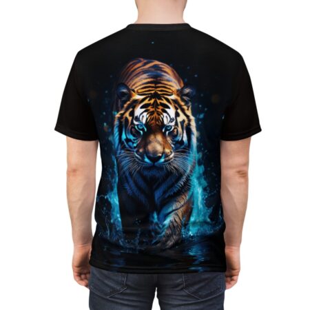 Dynamic tiger with glowing blue eyes walks through splashing water graphic on a black t-shirt.