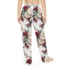 White pajama pants with a detailed all-over print of cream flowers, red berries, and dark green leaves.