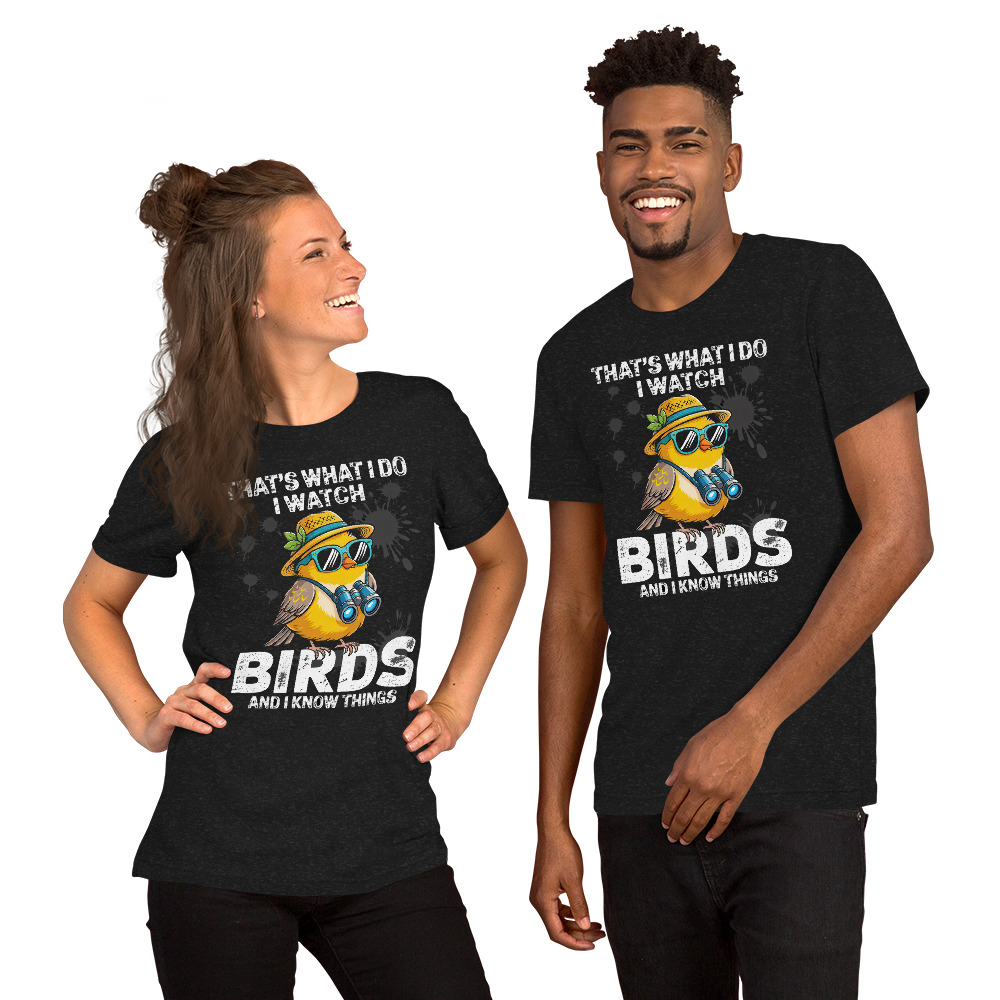 Dark grey t-shirt with a humorous graphic of a bird wearing sunglasses and a hat, holding binoculars, with text 'That's What I Do I Watch Birds And I Know Things'.
