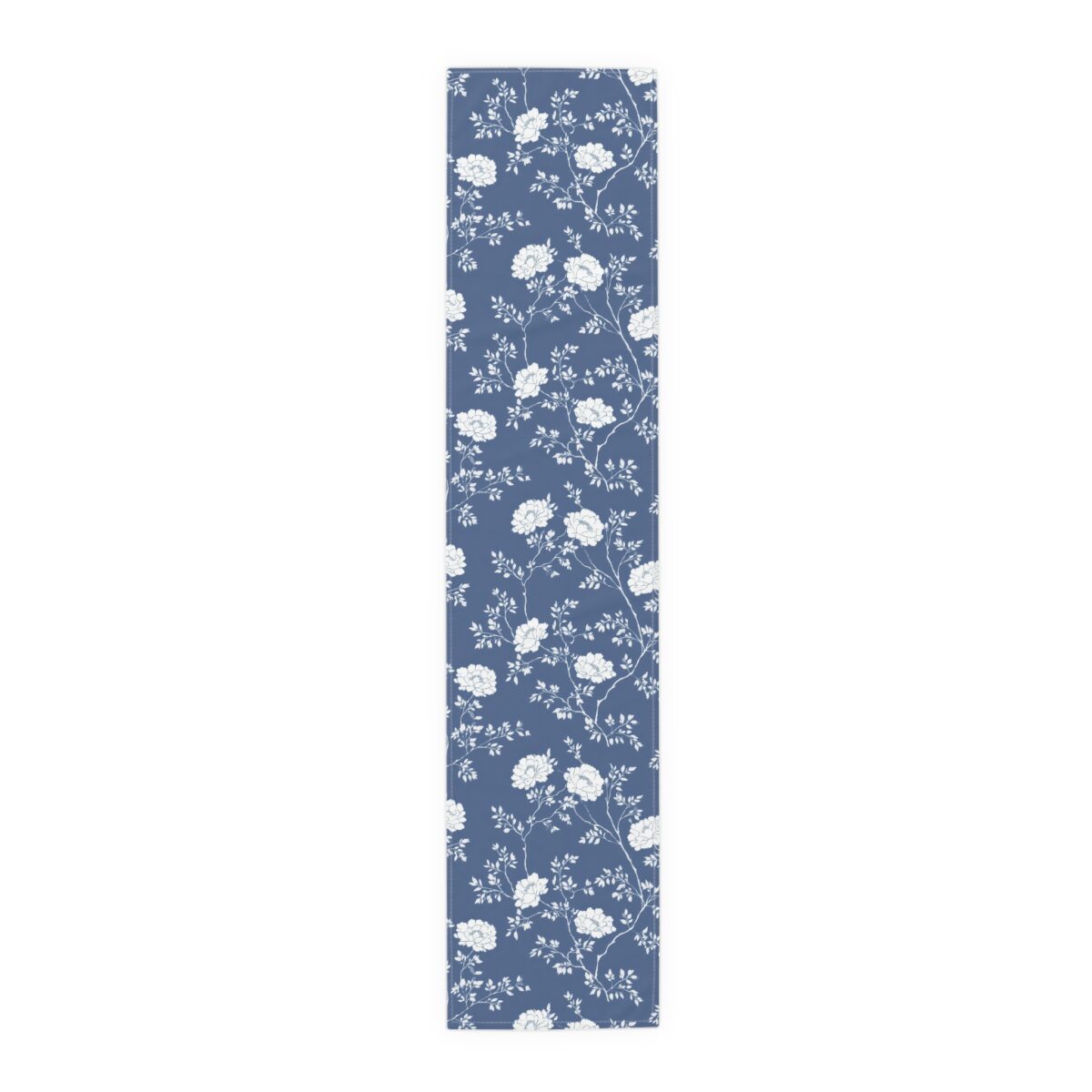 Blue table runner with an all-over white floral pattern, featuring delicate blooming flowers and leaves.