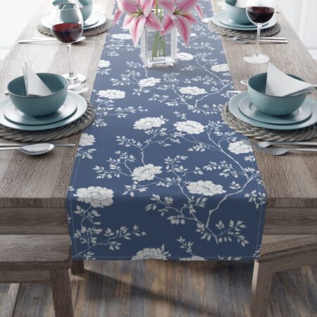 Blue table runner featuring a repeating white floral and branch pattern. Perfect for elegant dining and home decor.