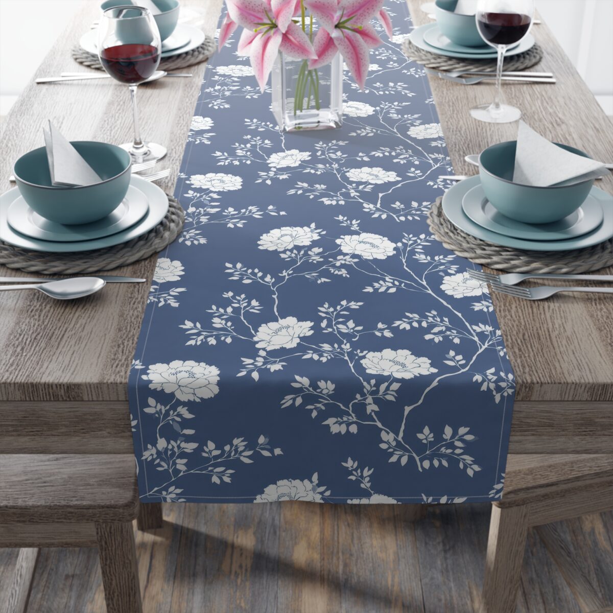 Blue table runner featuring a repeating white floral and branch pattern. Perfect for elegant dining and home decor.