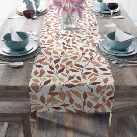 Table runner with a brown and orange leaf pattern on a white background. Perfect for autumn decor.