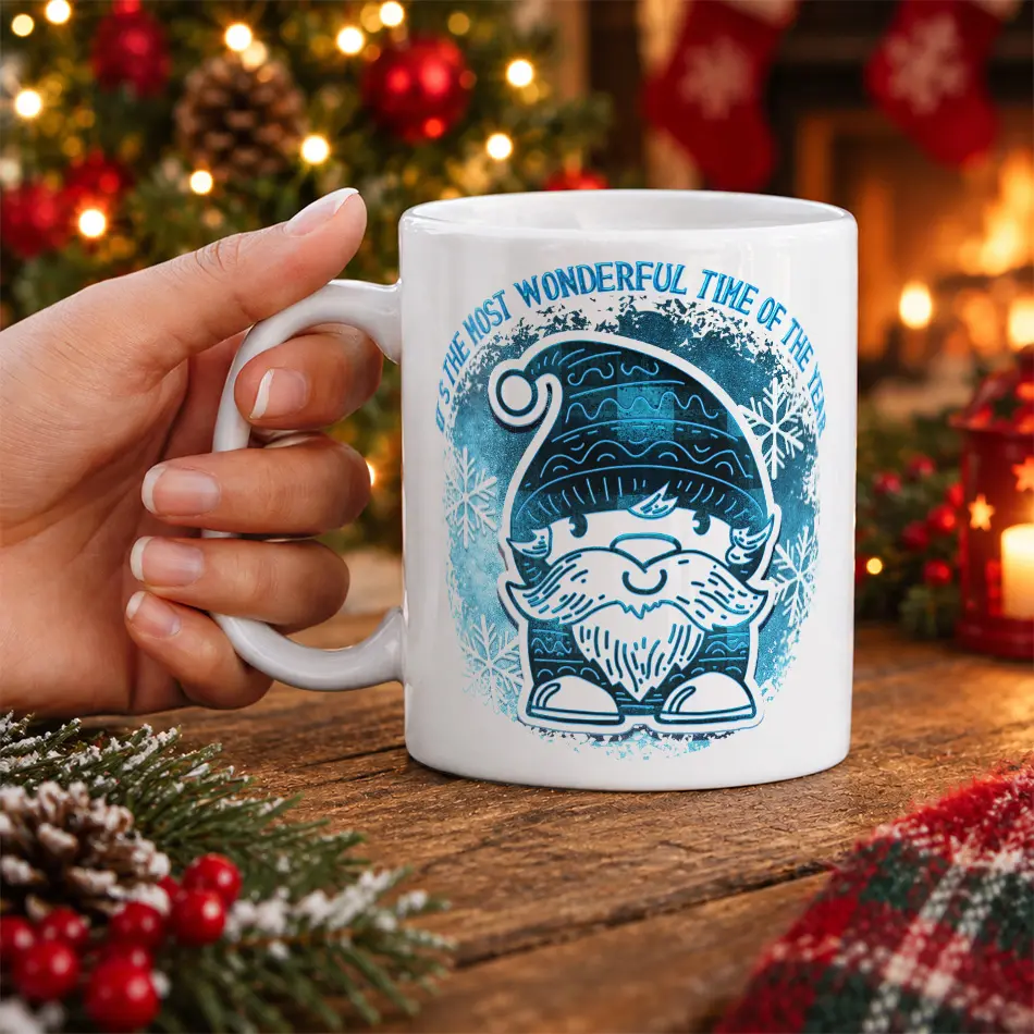 White ceramic coffee mug featuring a blue patterned winter gnome and snowflakes with holiday text design.