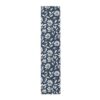 Navy blue table runner featuring a white daisy floral and leaf pattern all over.