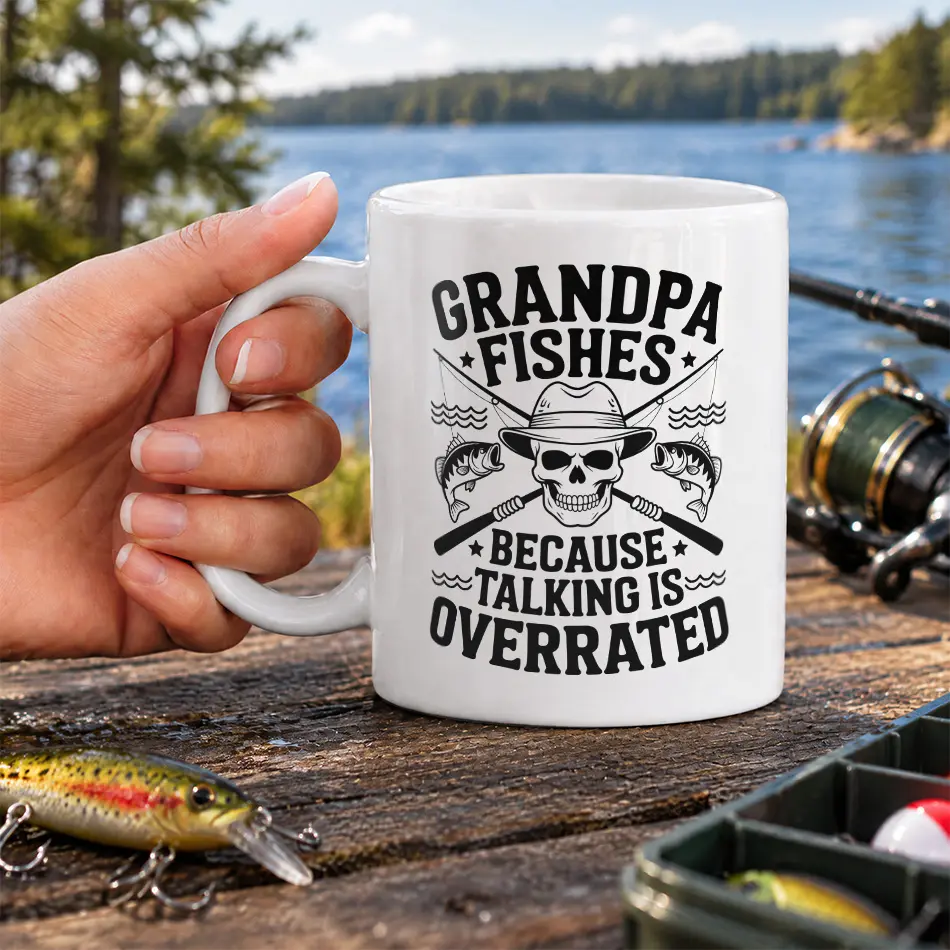 White ceramic mug printed with skull, fishing rods, and text reading Grandpa Fishes Because Talking Is Overrated.