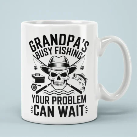 Black skull wearing hat with crossed fishing rods on a white ceramic mug reading Grandpa's Busy Fishing.