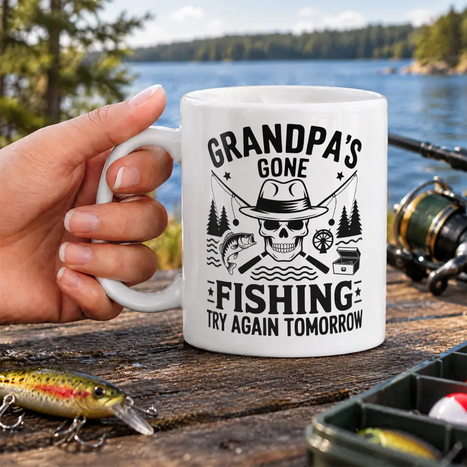 White ceramic coffee mug featuring a black fishing skull design and Grandpas Gone Fishing graphic text.