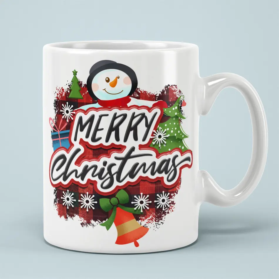 White ceramic mug with a smiling snowman, red buffalo plaid background, Christmas trees, bell, and Merry Christmas text.