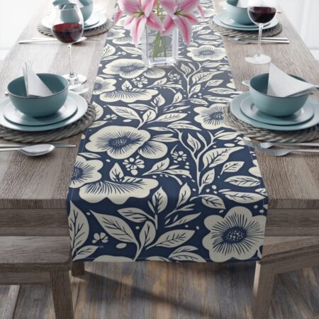 Navy blue table runner with a cream floral and leaf pattern, perfect for a farmhouse or vintage kitchen table setting.