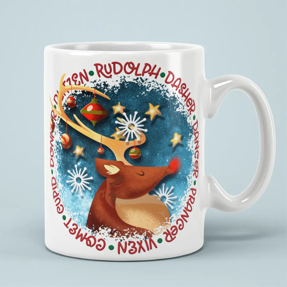 White ceramic mug featuring a red-nosed reindeer surrounded by ornaments, snowflakes, stars, and reindeer names.