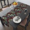 Vintage grape vine and leaf pattern table runner on a dark wood dining table.