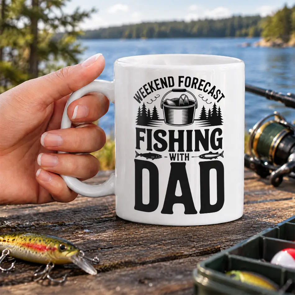 White ceramic coffee mug featuring black Weekend Forecast Fishing With Dad typography alongside pine trees and fish graphics.